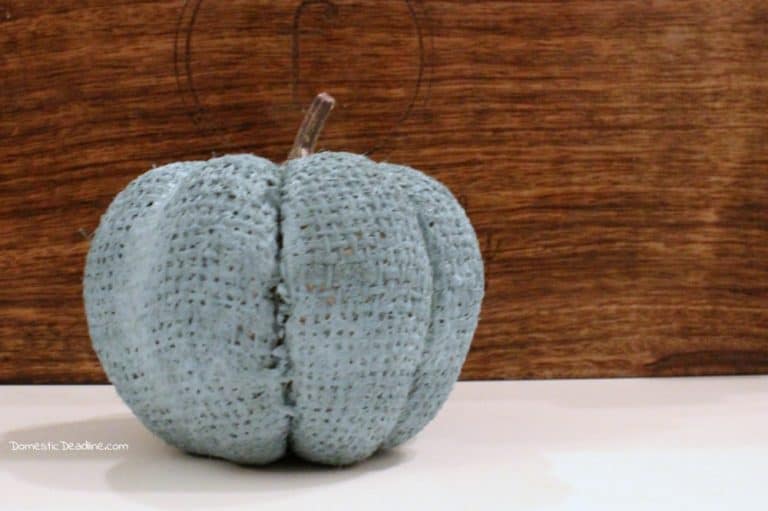 Inexpensive looking dollar store pumpkins get a quick makeover to more trendy teal pumpkins. The burlap texture still shows through, quick and easy! www.domesticdeadline.com