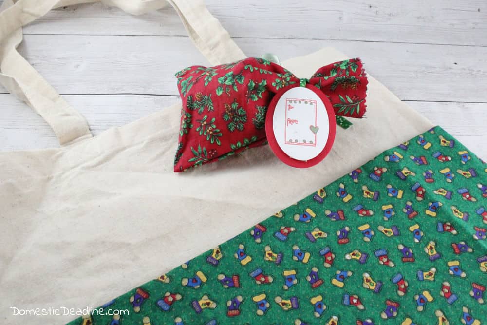 Use leftover fabric and freebie tote bags to make custom reusable gift bags to gift wrap your holiday gifts this Christmas season. Plus more upcycled projects www.domesticdeadline.com