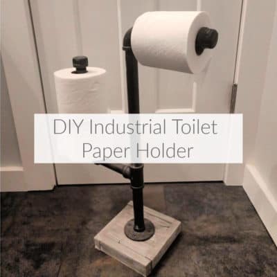Learn how to use industrial gas pipe to make a toilet paper holder to dispense and hold extra rolls. Perfect for industrial farmhouse decor! DomesticDeadline.com