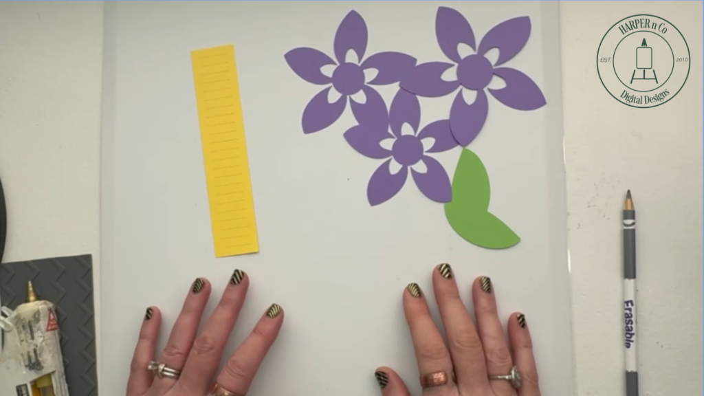 Cut pieces for a layered 3D paper flower including flower layers, center, and leaves