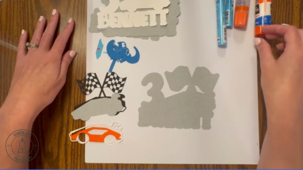 All cardstock pieces cut and organized for assembling a layered custom cake topper.